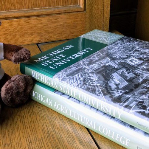 A toy platypus and books about the history of MSU